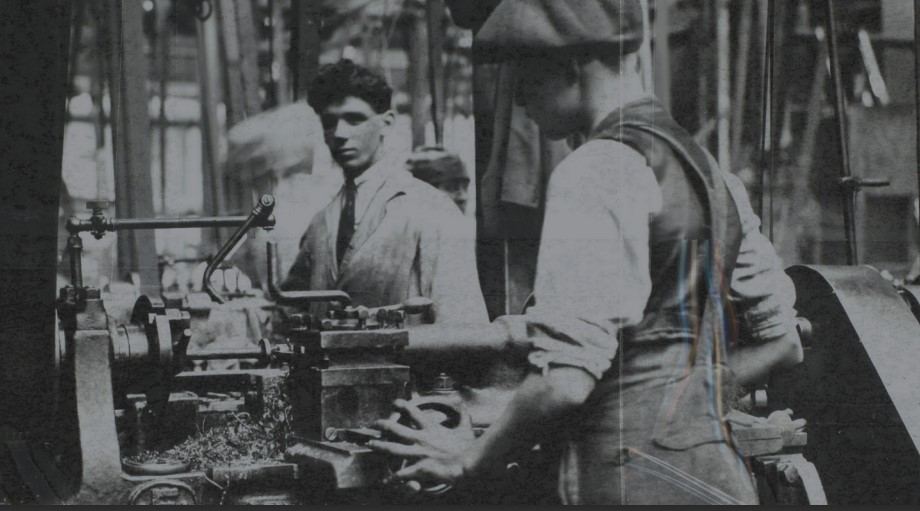 Turn-of-the-Century industrial workers at their machines.